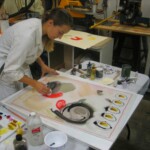 Erin Morrison working on the plate. Behind her are the gouache paintings we will monotype over.