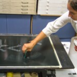 Erin subtracts ink from the acrylic sheet.