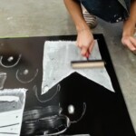 Erin adding fabric stencils to the inked plate.