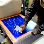 Mhiach subtracting the Akua ink before printing over one of his watercolor painted figures.